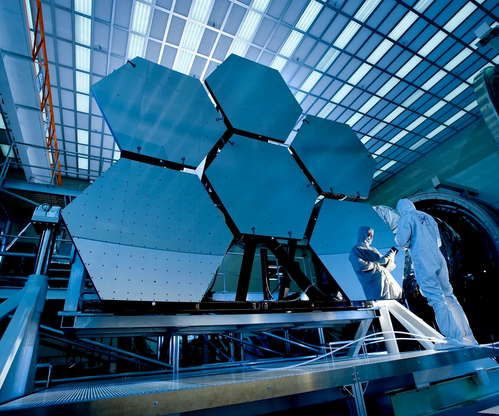A segmented mirror assembly under inspection in a high-technology facility.